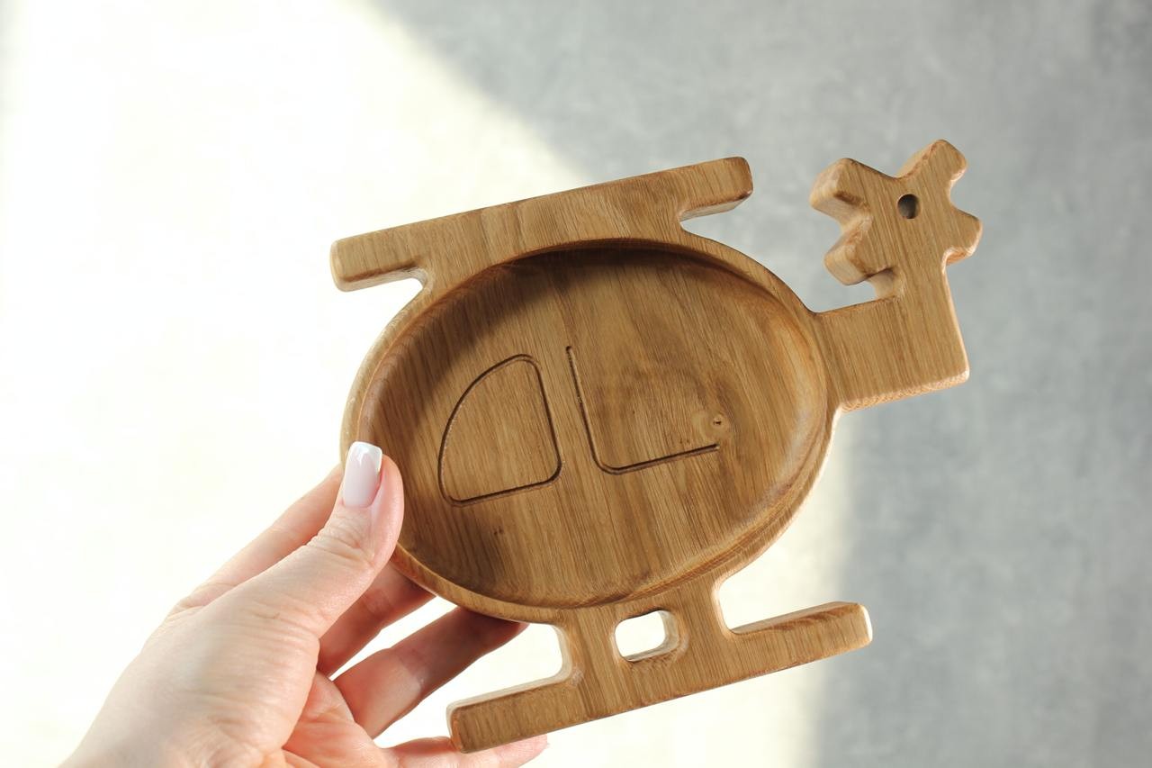 handmade wooden helicopter plate for kids on a rustic table, natural oak with smooth polished surface
