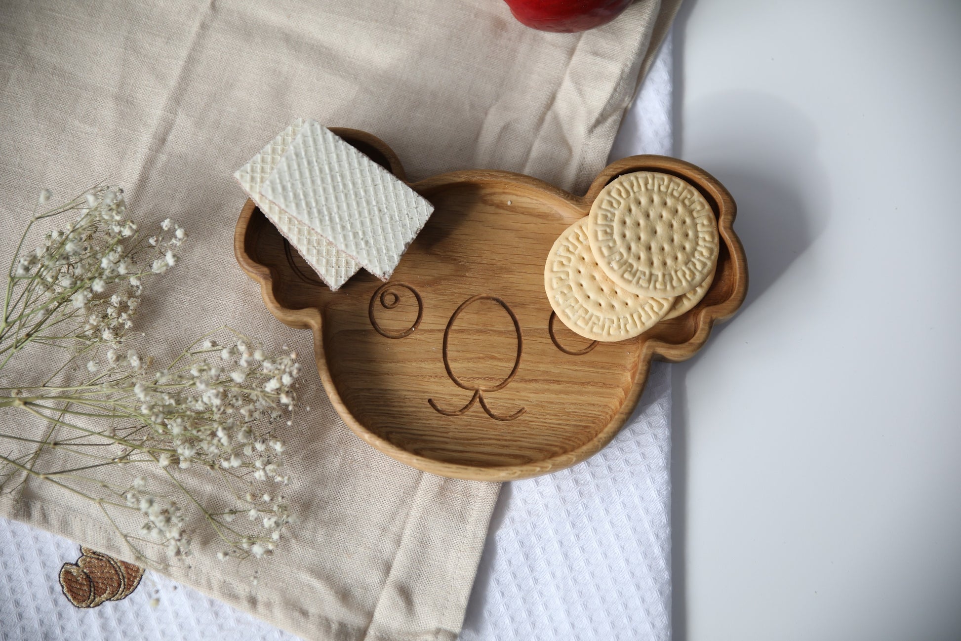 handmade wooden koala plate for kids on a rustic table, showcasing its smooth polished surface and natural wood grain
