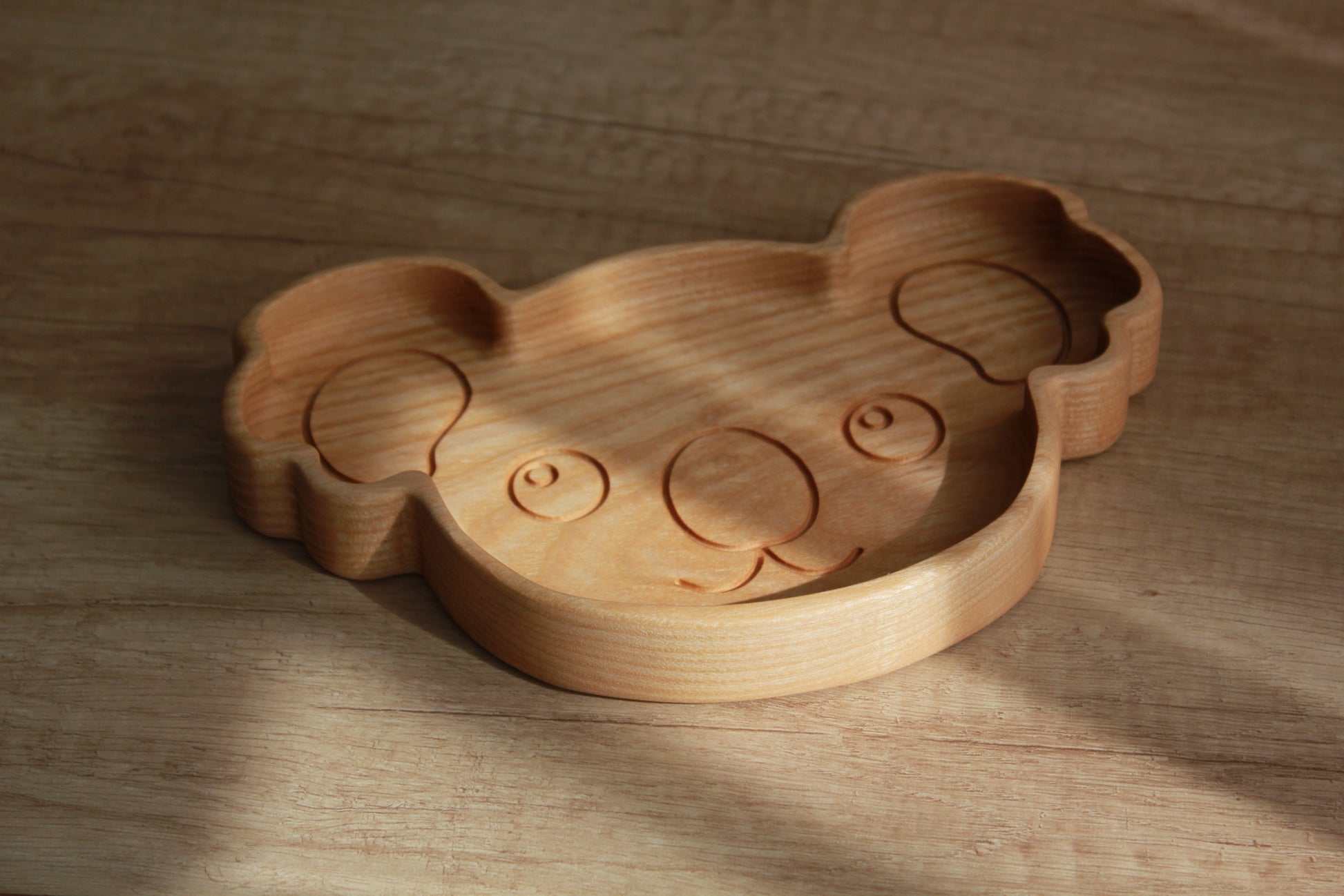 adorable koala wooden plate for kids on a rustic table, showcasing smooth hand-polished oak and playful engraved details