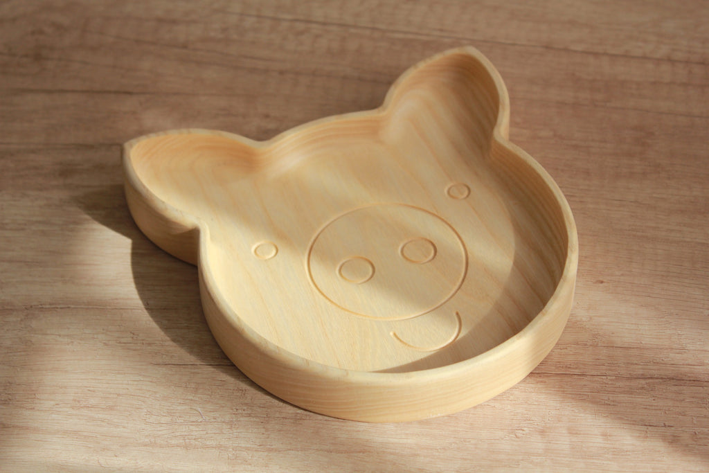 handmade wooden pig plate for kids on a rustic table, showcasing smooth oak finish and playful design
