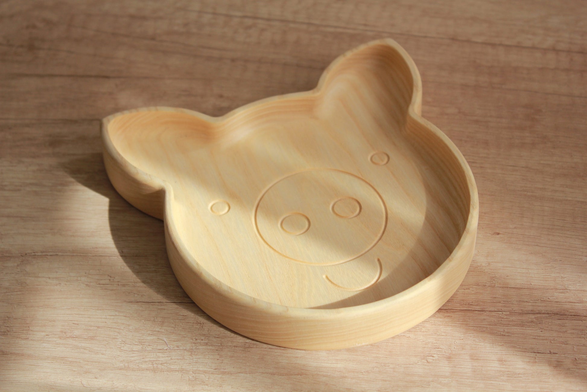handmade wooden pig plate for kids on a rustic table, showcasing smooth oak finish and playful design