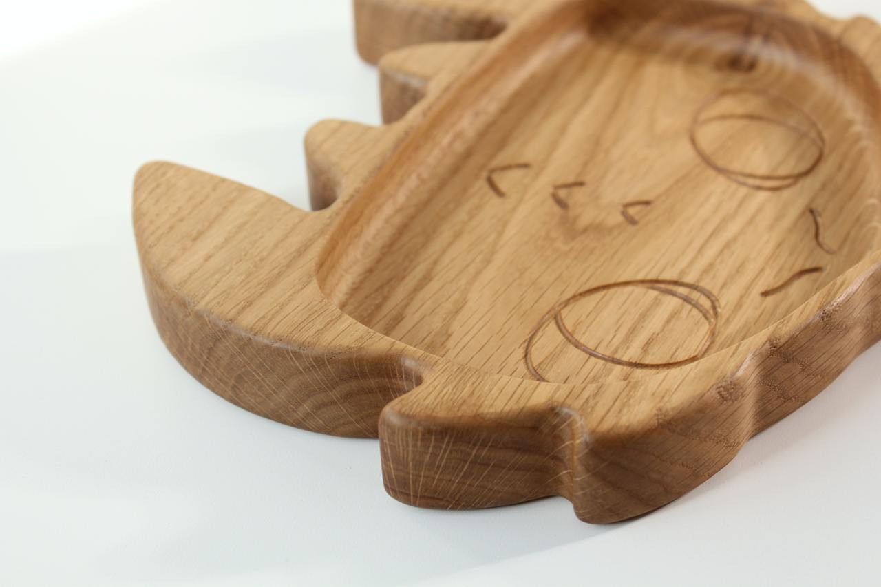 soft-lit wooden plate for kids with toothless design, hand-polished oak surface glowing warmly