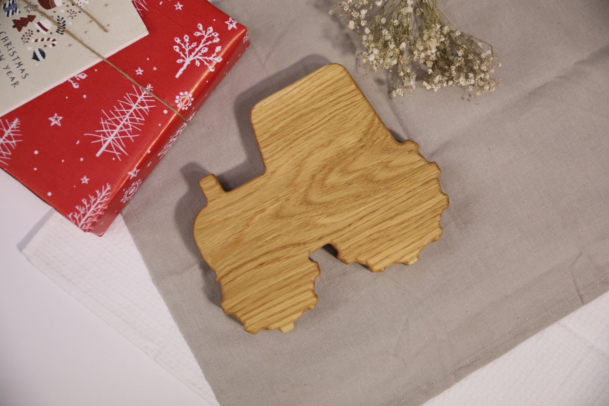 a soft-lit close-up of a handcrafted oak kids plate with a charming tractor design