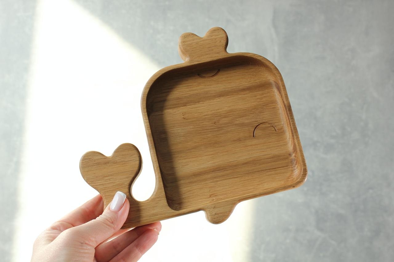 soft-lit wooden whale plate for kids, hand-polished oak with smooth curves, resting on a cozy kitchen table